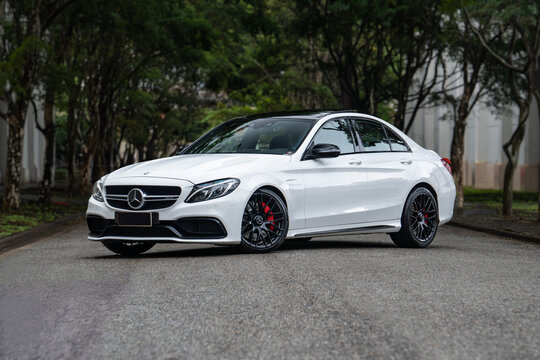White Mercedes AMG C63 front three quarters view outdoors, Luxury sports car on scenic road