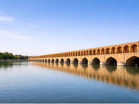 Historic bridge over the Zayanderud River in Isfahan, Iran, Persian architecture reflected in the water, clear sky and ample space for text in horizontal composition