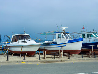 Fototapeta premium Boats docked at the harbor on a cloudy day in a coastal town during late afternoon hours