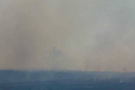 Rural firefighters are battling a grass/brush fire in heavy smoke