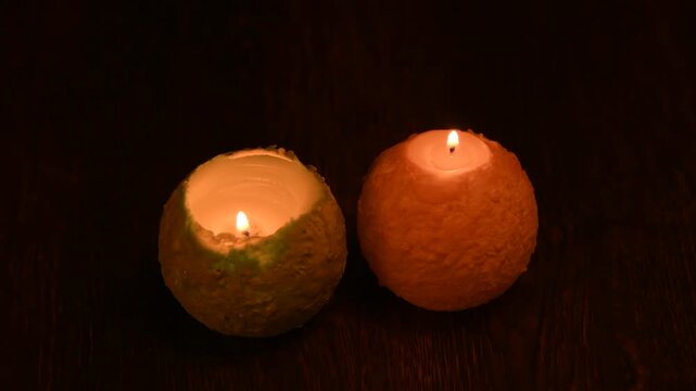木のテーブルの上で炎が揺れる丸いキャンドル。