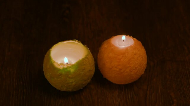 木のテーブルの上で炎が揺れる丸いキャンドル。