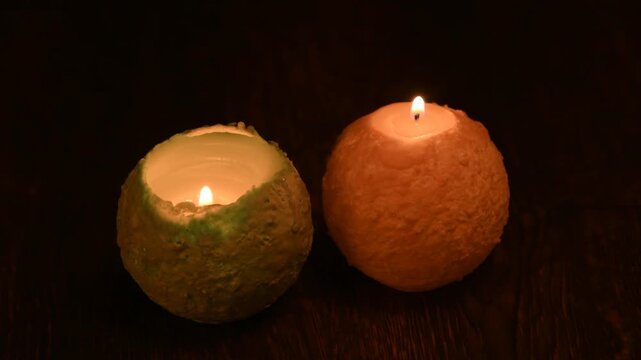 木のテーブルの上で炎が揺れる丸いキャンドル。