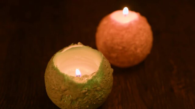 木のテーブルの上で炎が揺れる丸いキャンドル。