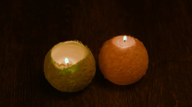 木のテーブルの上で炎が揺れる丸いキャンドル。