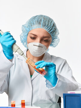 Young european female scientist with micropipette transferring sample into microcentrifuge tube