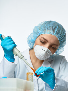 Young european female scientist using electronic micropipette to transfer liquid into vial