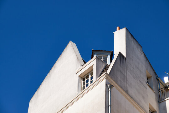 Haussmannian rooftop with dormer window against clear Paris spring sky