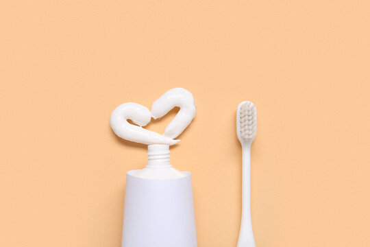 Drawn heart with toothbrush and toothpaste on color background.