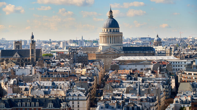 Panth&eacute;on rising above Paris rooftops with spring light and blue sky and city skyline