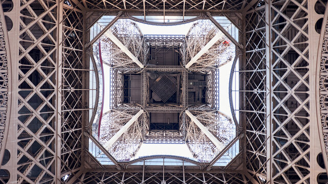 Eiffel Tower from below with intricate iron lattice and geometric symmetry in spring