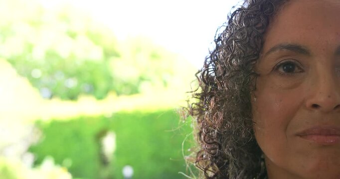 African American woman opening eyes at sunlight smiling at door backlit garden ear stud, copy space