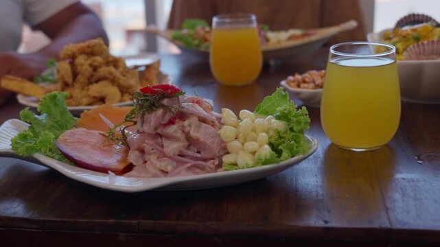 People enjoying peruvian ceviche and fried seafood at a restaurant by the sea