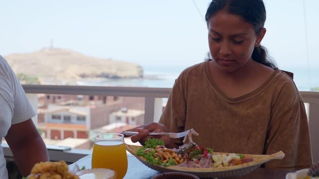 Peruvian woman eating ceviche and seafood at a waterfront restaurant