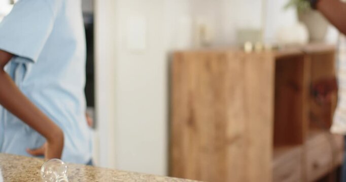 African American father and son child reaching for bulb on granite counter dad showing lamp safety