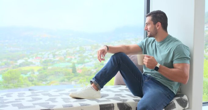 Sipping casual man holding mug on home window bench while camera tightening, relaxing, copy space