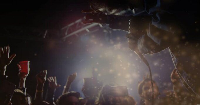 Vertical video: Leaning singer reacting to light and crowd at club in denim, wired mic, copy space