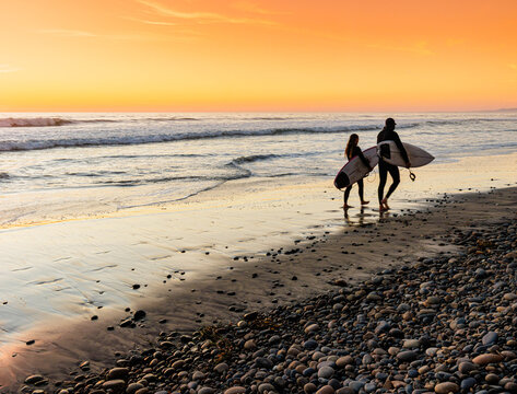 Surfers With Surfboards Walking Down Grandview Surf Beach at Sunset, Encinitas, California, USA