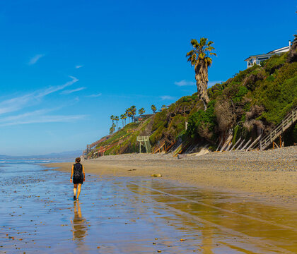 Reflection of Female Tourist Walking on Grandview Surf Beach, Encinitas, California, USA