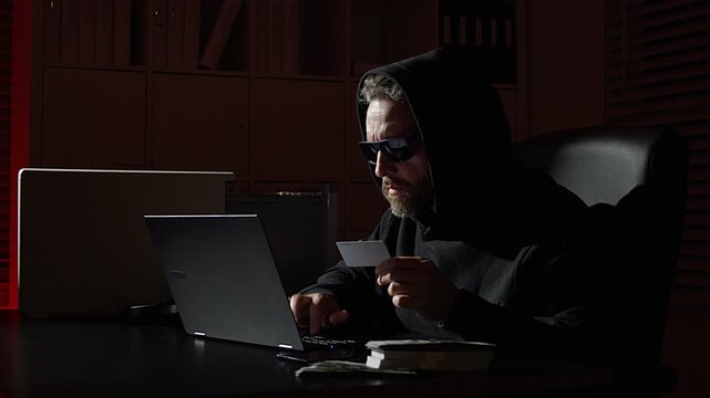 Hacker attack. IT hacker online attack. Cybercrime hackers risks online privacy. Hacker theft. Hacker typing code in laptop at night office. Network security, hacking and computer crime.
