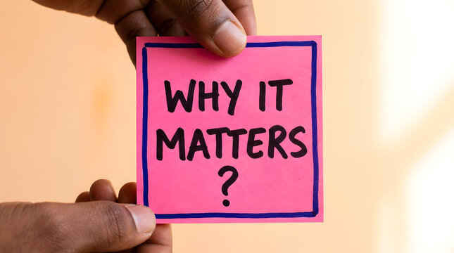 Hands holding pink sticky note with 'why it matters' question in black text on blurred background