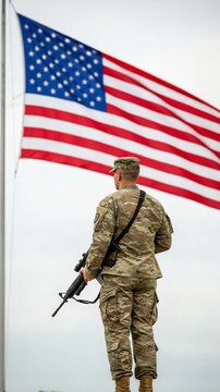 Patriotic US Army Soldier in Camouflage Standing Guard with Rifle Before American Flag