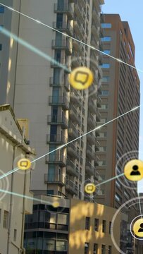 Vertical video: Upward tilt sparking AR overlay over tower, yellow nodes forming blue web for tech