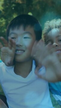 Vertical video: Cam pulling, two boys leaning into lens, reaching, creating social ad with sunspots