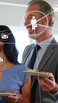 Vertical video: Colleagues talking at buffet sparking UI nodes over plates, faces mapping biz links