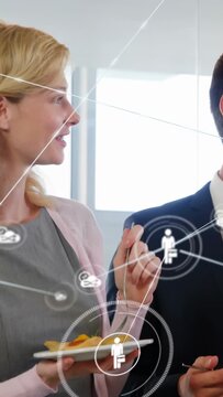 Vertical video: Woman with plate and fork turning to man and sparking node map for office network