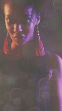 Vertical video: Camera tilting, musician playing keys and singing, performing, bokeh haze glowing