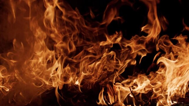 Fire flames moving in darkness. Fire burning with natural glow. Fire blazing cinematic motion. Fire background for visual effects.