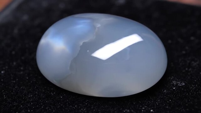 Smooth, milky blue-grey chalcedony gemstone cabochon closeup