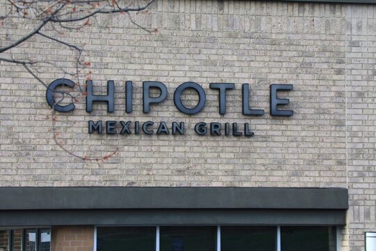 Chipotle Mexican Grill sign on the building storefront. Chipotle is a chain of American restaurants serving mexican food