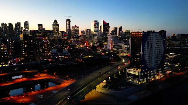 Aerial drone view of downtown Montreal skyline at night with city lights in Quebec, Canada