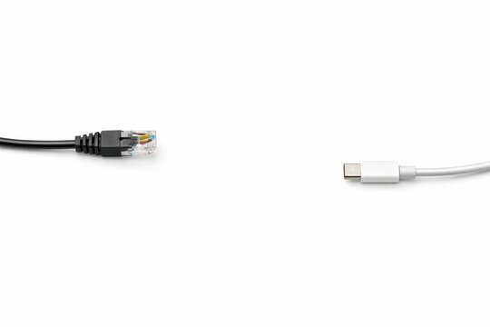 Black ethernet cable and silver usb type c cable entering from opposite sides with clean center copy space premium data transfer concept