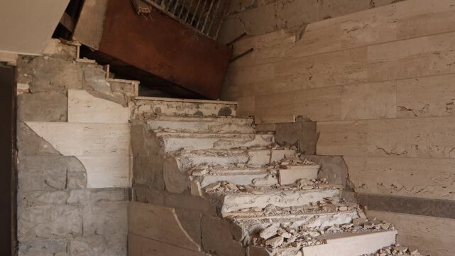 Destroyed concrete staircase inside a building ruined during the Syrian Civil War in Ma'aloula, Syria. Evidence of urban warfare and conflict impact on historic architecture