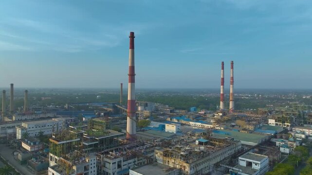 Drone shot of manufacturing plant with smokestacks and buildings in Nagda India daytime
Industrial factory complex aerial view with chimneys and pipelines in India daytime
Aerial view of refinery plan