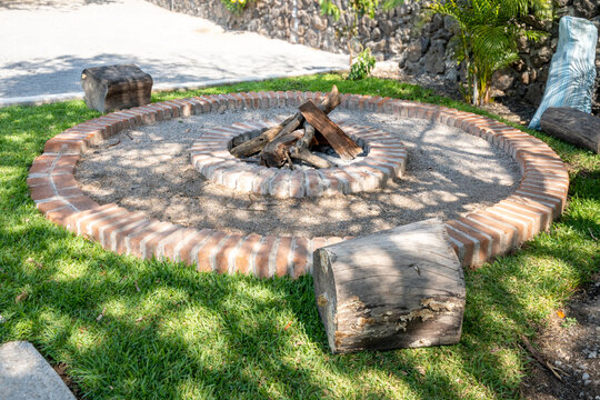 Outdoor backyard brick fire pit with log seating