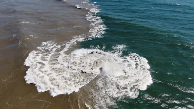 Aerial drone view of the confluence of muddy river water meeting clean ocean water