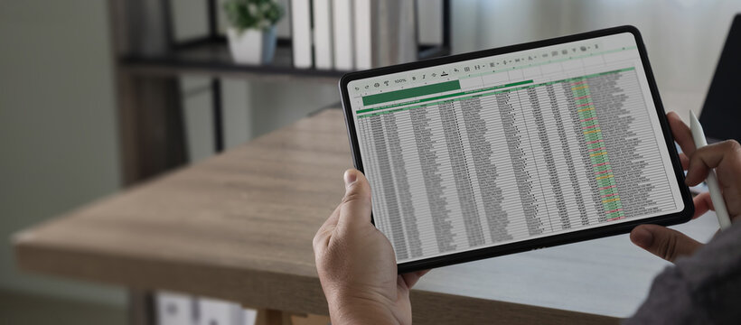 Hands holding screen displaying spreadsheet data excel office for data analysis technology process, supporting financial reporting, document review, and digital information management in workspace