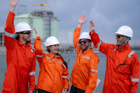 Team of engineers celebrating success at industrial terminal
