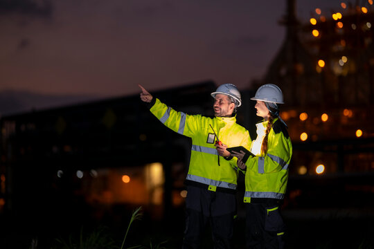Engineering team working at refinery site at night