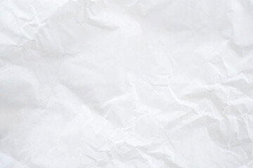Fototapeta premium White wrinkled paper texture background. This crumpled paper surface is ideal for use as a backdrop or abstract texture in branding