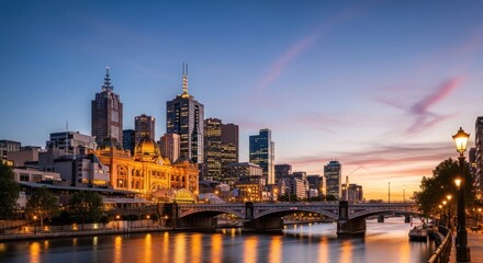 Obraz premium Melbourne City Skyline at Dusk Over Yarra River with Bridge and Lights.