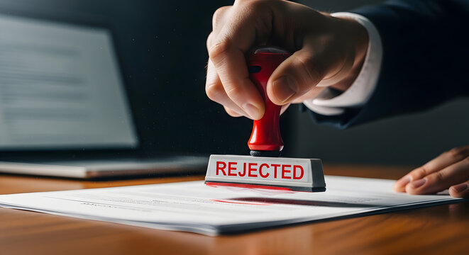 Rejected stamp on paper document held by businessman hand in office setting for visa or loan application
