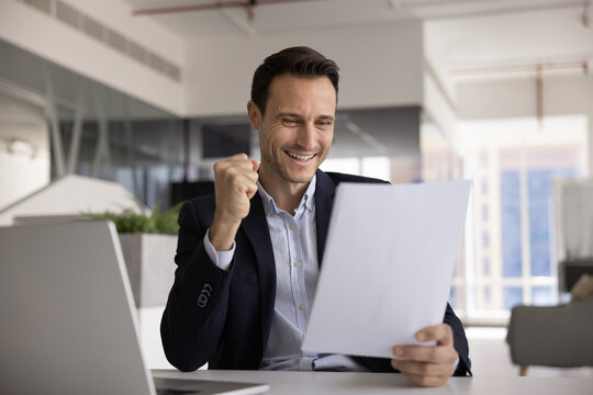 Successful Hispanic businessman celebrating legal agreement signed business contract authorized deal closed financial documents confirmed enjoying great sales results in official papers at office desk
