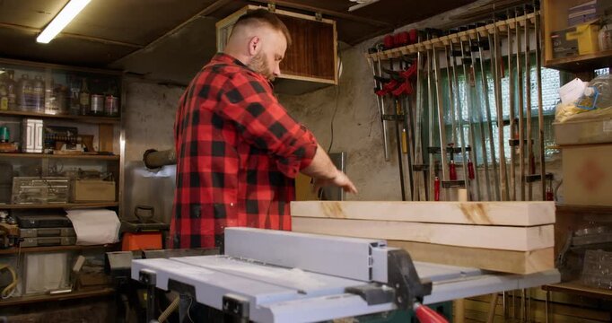 Woodwork service. Furniture making. Male joiner preparing smoothed plank for diy project in carpentry equipped with professional tools.