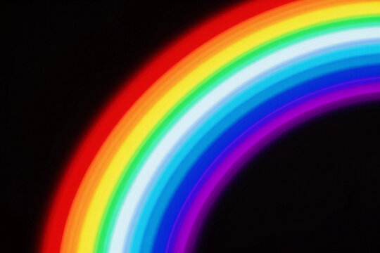 Vibrant rainbow arcs against deep black background.