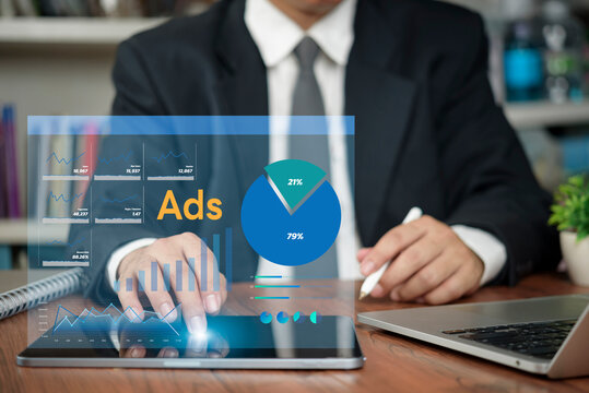 Businessman using digital tablet with virtual ads marketing dashboard hologram. Concept of digital advertising campaign, data analytics, online marketing strategy and ROI performance monitoring.